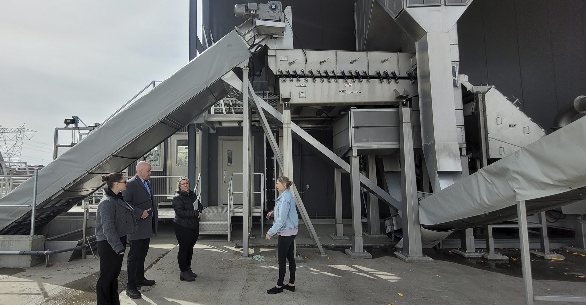 trois personnes discutant devant une usine de production de sirop d'érable